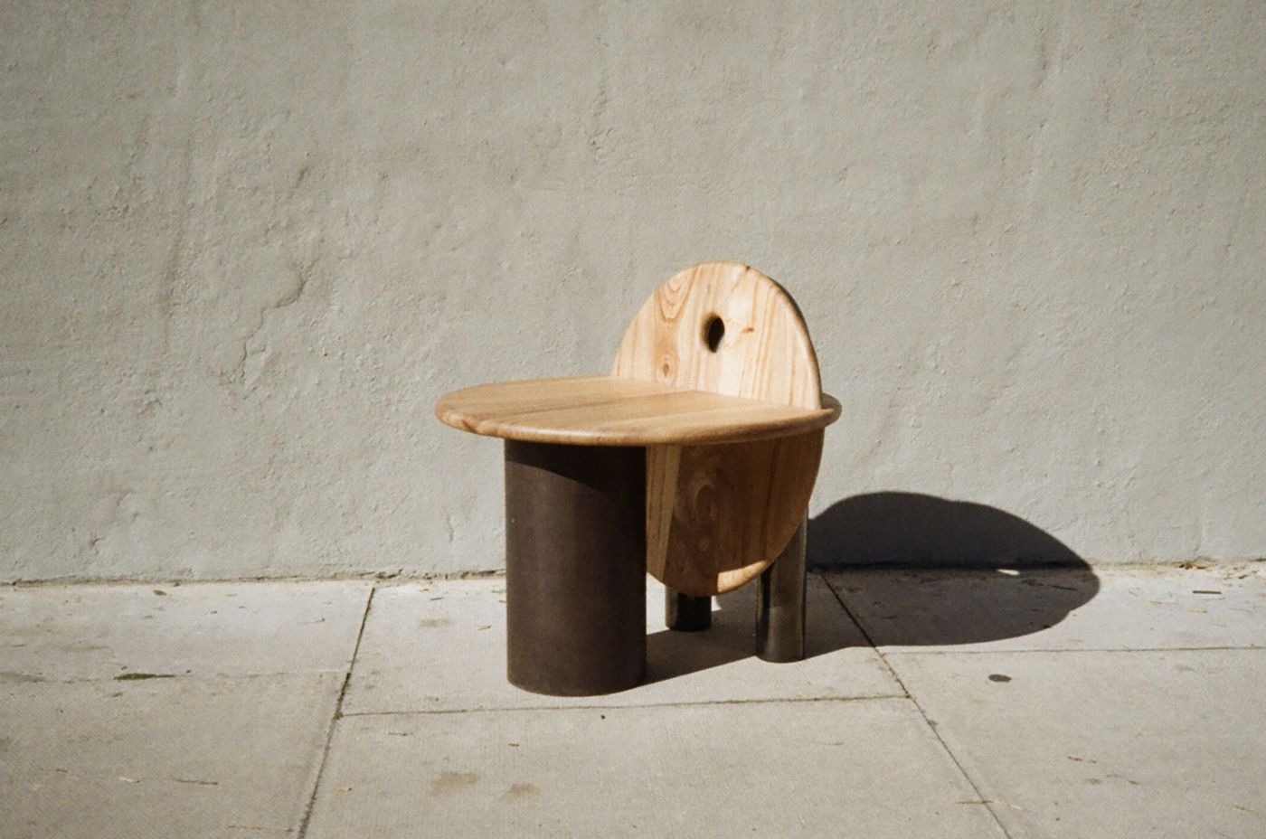 Raw mini stool, three-quarter view on its rusted steel legs