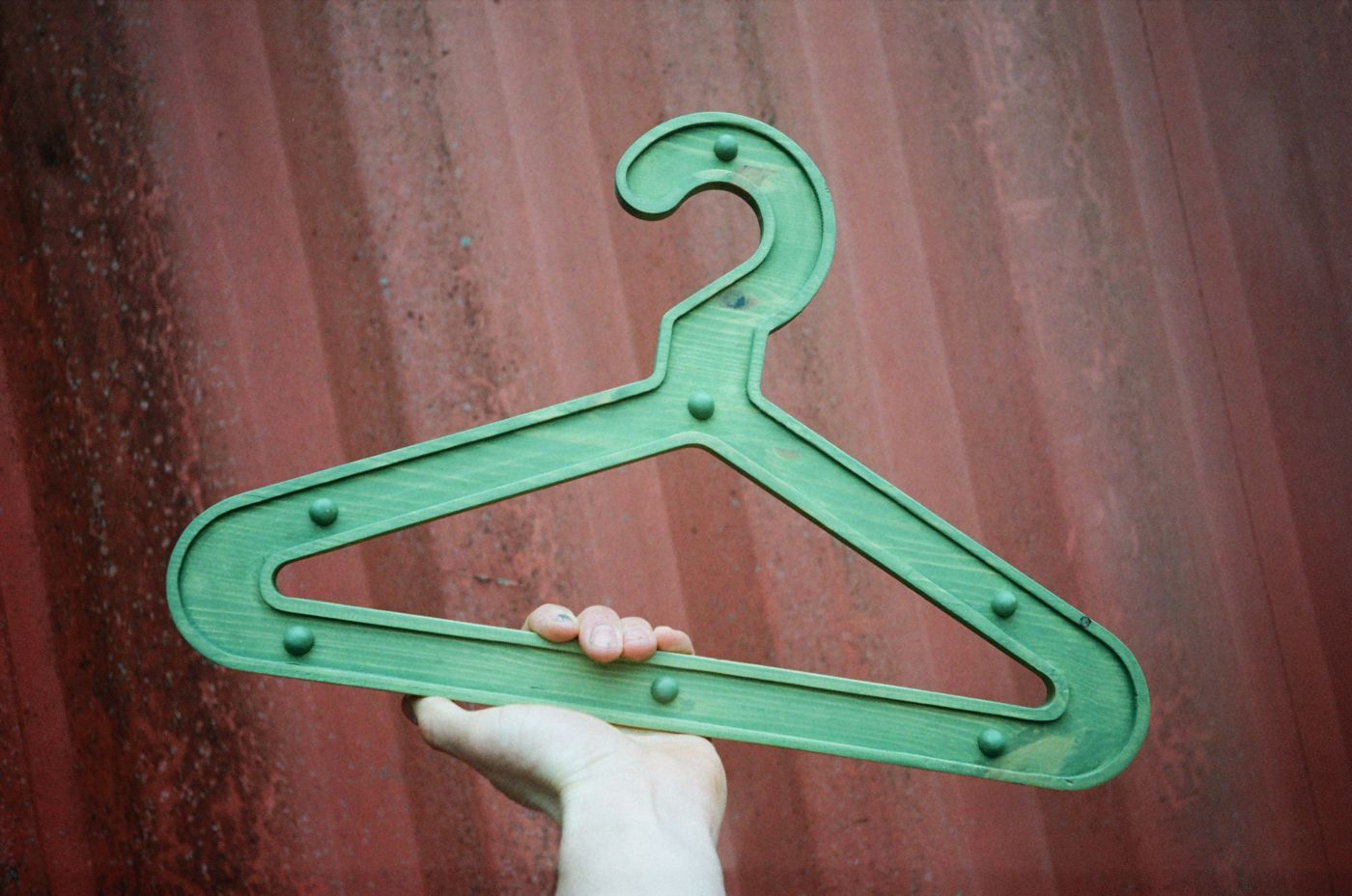 Green Girder Hanger held up against a red shipping container
