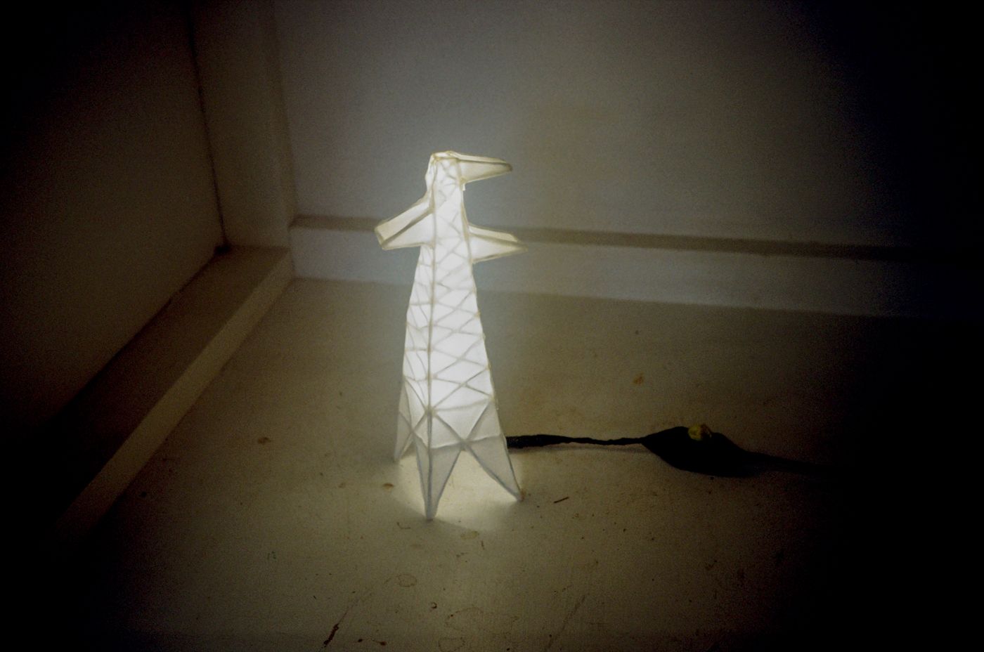 Small two-armed Pylon Lamp glowing in a dim corner