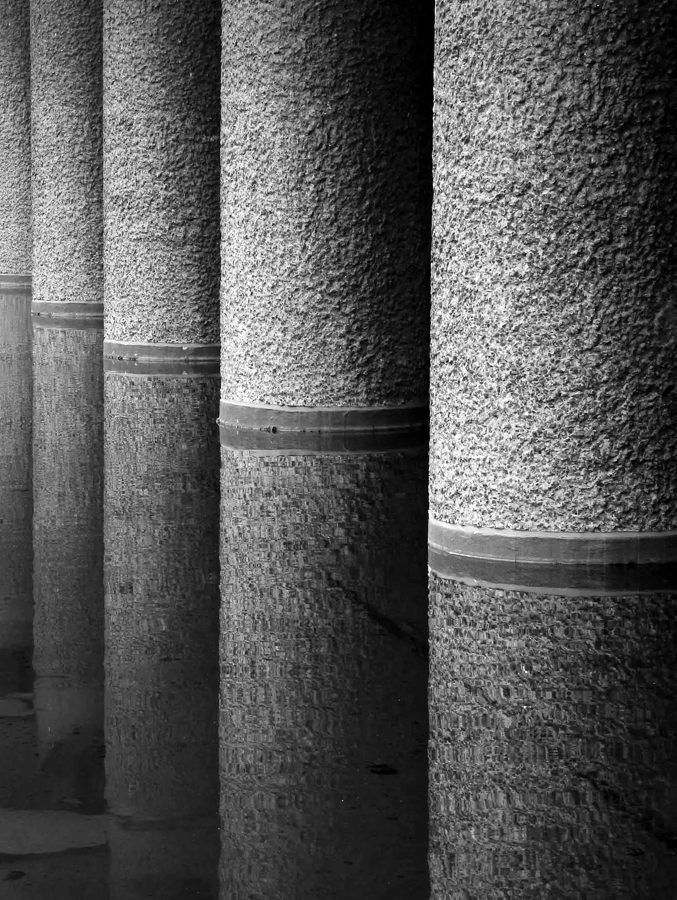 Textured concrete columns rising out of still water