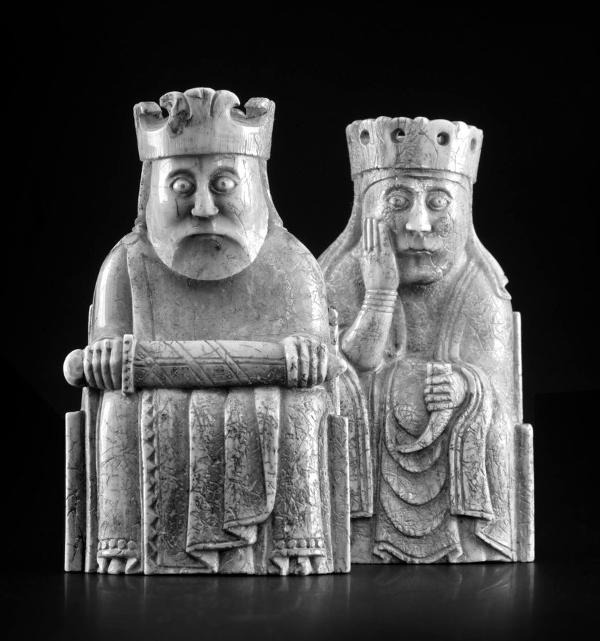 Two of the Isle of Lewis chess pieces, a seated king holding a sword across his knees and a queen resting her cheek on her hand