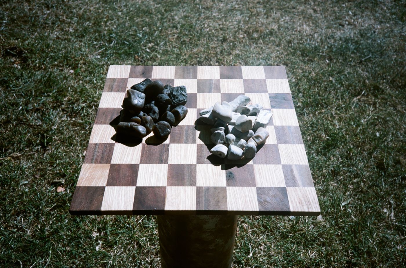Dark and pale pieces gathered in two piles on the board